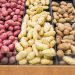 Grocery store displays different colors and varieties of potatoes for people to select their favourite, agricultural produce arranged in lines.