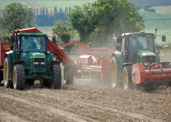 Leve pòmdetè ak yon traktè ak yon machin rekòlte toupre Bonby, North Lincolnshire, Angletè, an 2011.